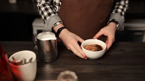 Barista pouring milk into coffee while preparing it in coffee shop Stock Footage 111272964