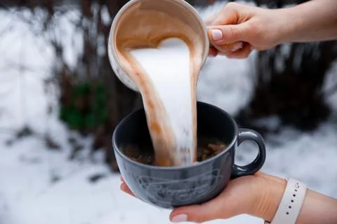 Barista pours milk into a cup of coffee Stock Photos