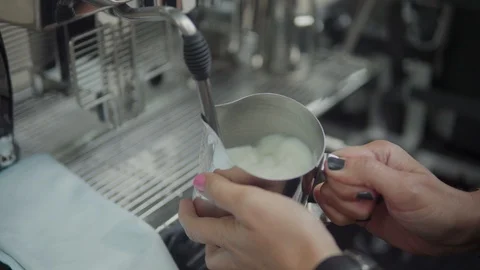 Barista is preparing coffee. Steaming and frothing milk for cappuccino or latte. 動画素材 116333590