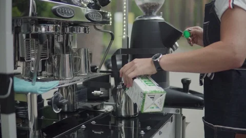 Barista is preparing coffee. Steaming and frothing milk for cappuccino or latte. 動画素材 116334555
