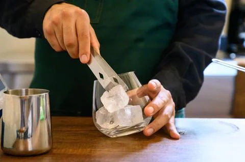 Barista preparing cold drink adding ice to glass Stock Photos