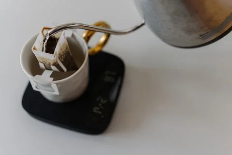 Barista preparing drip coffee using kettle, precision kitchen scales and drip Stock Photos