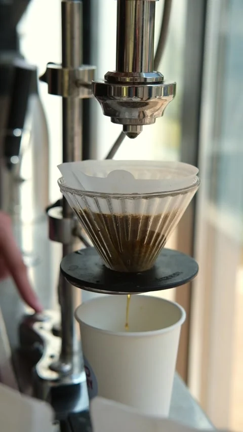 Barista preparing pour-over coffee using a professional coffee brewing machine Stock Footage 346693686