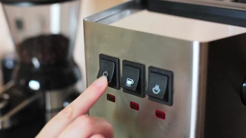 Barista press a finger on the button for turning on an coffee machine Stock Footage 169814670