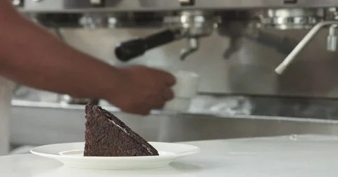 Barista put a cup of coffe on first plane to a chocolate cake Stock Footage 77644041