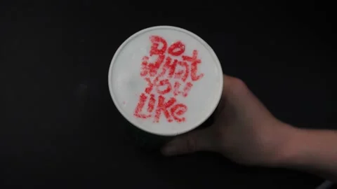 Barista puts coffee with red Do What You Like words on table Video stock 144490906