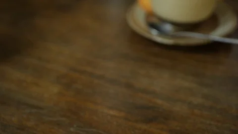 Barista puts on the table a cup of coffee with latte art. Hands puts cup of Stock Footage 117226036