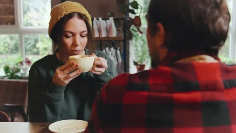 Barista serves coffee while customers enjoy drinks at a cafe during morning hour Stock Footage 330788291