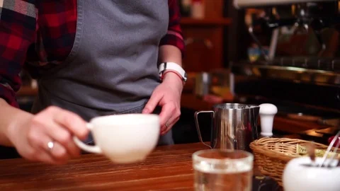 Barista serving white coffee cup on wooden board with glass of water in close up Stock Footage 104372187