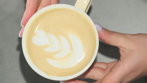Barista shows prepared coffee with pattern placing cup on table Stock Footage 306615440