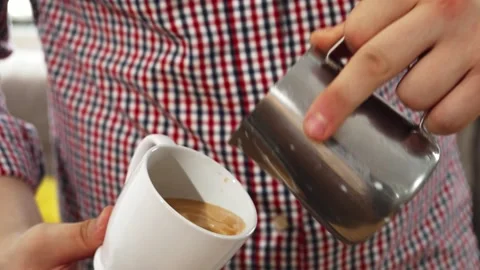Barista skillfully creating latte art in cappuccino Stock Footage 311944619
