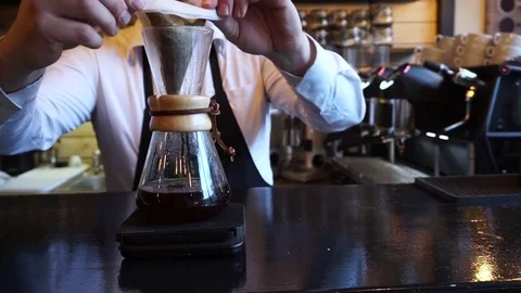 Barista squeezing the last drop of alternative brew style Chemex coffee Video stock 84835817