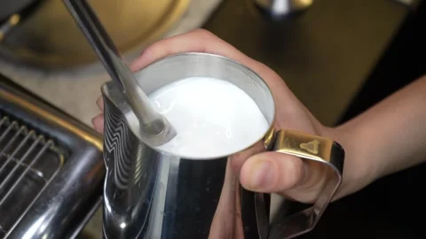 The barista steams the milk. The process of creating milk foam. Latte making Stock Footage 246832707