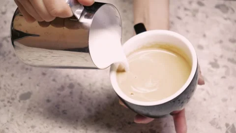 The barista steams the milk. The process of creating milk foam. Latte making Stock Footage 246832861