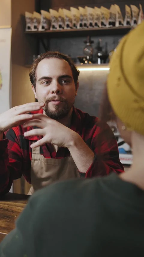 Barista talks to customer in cafe about coffee preparation and roasting techniqu Stock Footage 330788839