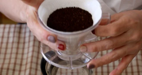 Barista tapping ground coffee inside dripper to make it flat Stock Footage 103297684