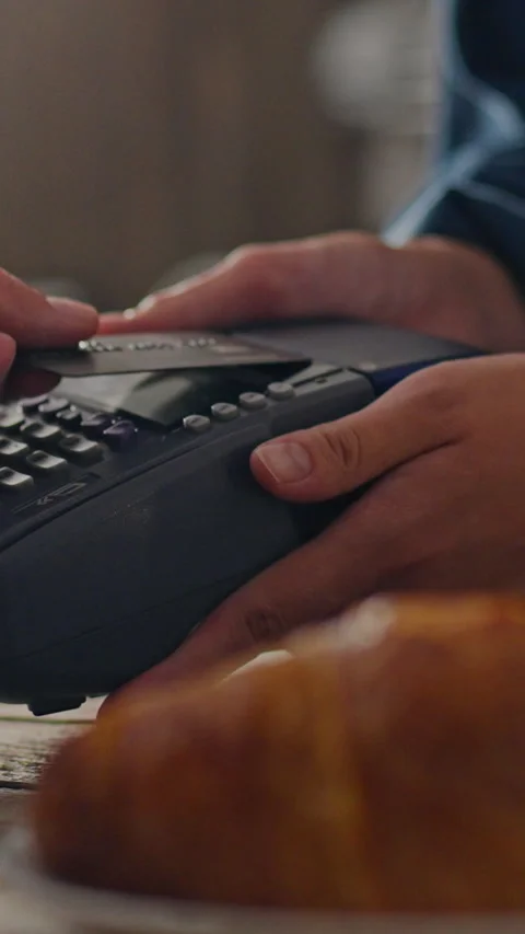 A barista uses a terminal to pay for a hot drink order Stock Footage 331528702