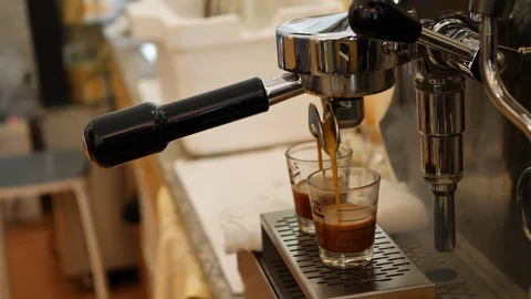 Barista using coffee machine pouring in glass cup with steam in cafe restaurant Stock Footage 93769092