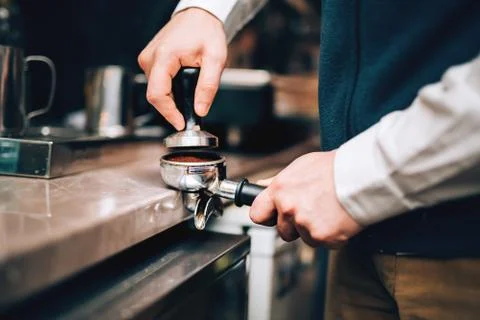 Barista using coffee machine preparing fresh coffee with latte foam at coffee Stock Photos