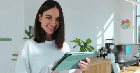 Barista using digital tablet in cafe. The female staff are checking the products Stock Photos