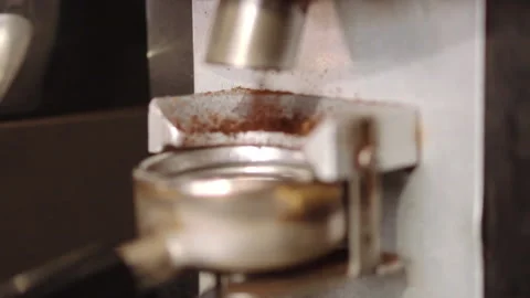 Barista using a tamper to press ground coffee into a portafilter Stock Footage 157980897