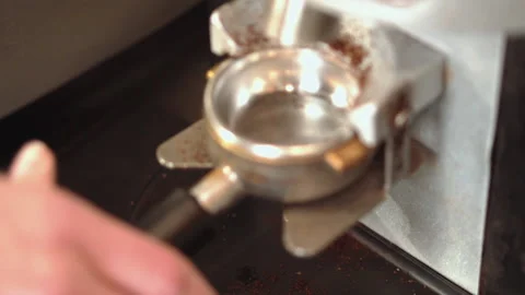 Barista using a tamper to press ground coffee into a portafilter Stock Footage 157981019