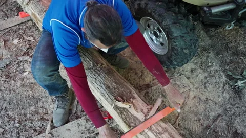 Bark Stripping: Man Using a Drawknife to Debark a Rough-Cut Log Video stock 321308517