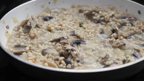 Barley mushroom risotto cooking in a pan Stock Footage 88110981