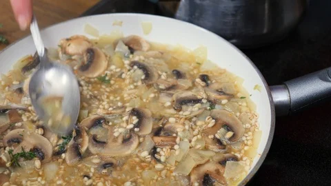Barley risotto slowly cooking down in a pan Stock Footage 88110979