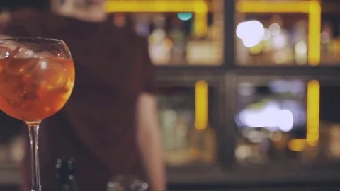 The barman at the bar counter puts an orange in a cocktail Stock Footage 74960256