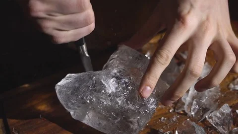 Barman chopping ice using a special knife. ?hunks of ice flying around Stock Footage 83784485