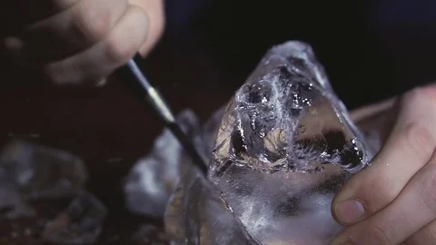 Barman chopping ice using a special knife. ?hunks of ice flying around Stock Footage 83786308