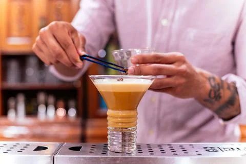 Barman decorating alcoholic drink called irish coffee. Stock Photos