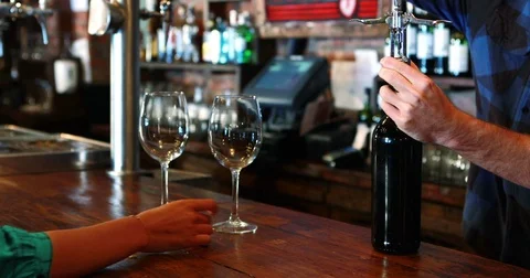 Barman opening wine bottle with corkscrew at bar counter Stock Footage 72941654