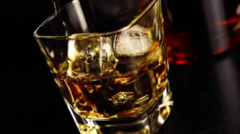 Barman pouring whiskey on bar table in front of bottles 스톡 동영상 46915052