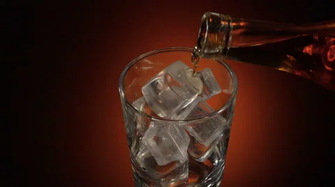 Barman pouring whiskey in the glass on table with reflection, warm evening Stock Footage 65780823