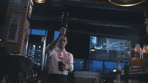 Barman pours a drink in a beaker Stock Footage 73761464