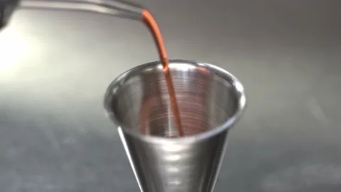 Barman pours raspberry syrup into the metal jigger Stock Footage 160716009