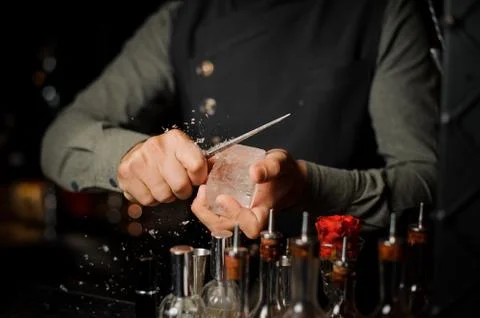 Barman preparing a large rectangular piece of ice Fotos Stock