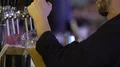 Barman professionally fills up glass of unfiltered wheat beer, pouring technique 4k or 4k+ Resolution