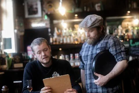 Barman serving customer  looking at menu in traditional Irish public house Stock Photos