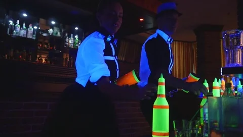 Barman show. Two barmen juggle bottles and Beaker for mixing . slow motion Stock Footage