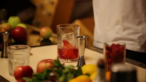 Barman stirs a thin spoon with a cocktail in a glass with ice Stock Footage 118323563