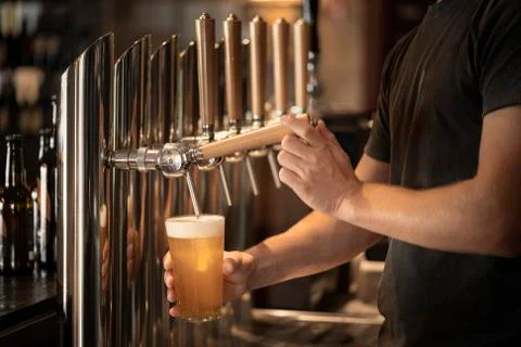Barman who is tapping a beer 스톡 사진