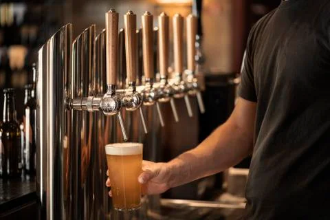 Barman who is tapping a beer Stock Photos