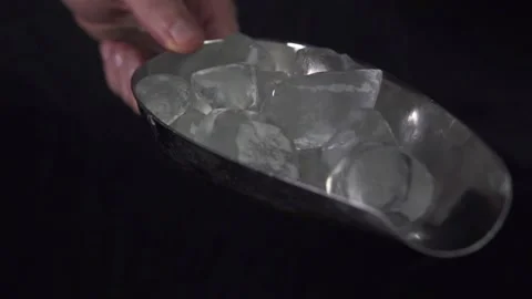 A barman's hand transferring ice from ice scooper into a cocktail shaker. Stock Footage 133344944