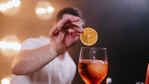Barmen puts orange slice into aperol spritz cocktail glass. Steadicam shot Stock Footage 136197586