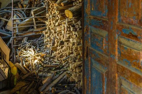 Barn with chunks of firewood behind old door Stockfoto's