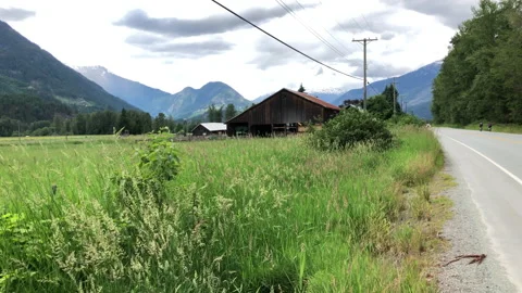 Barn in mountain valley, cyclists Stock Footage 146989284