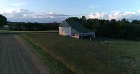 A barn surrounded by a wheat field in the rural Pennsylvania countryside during  Video stock 133732130